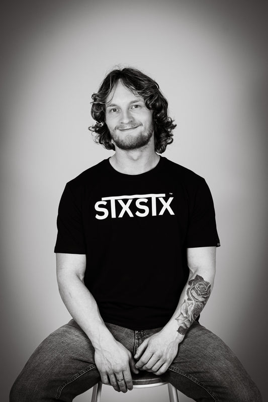 Man wearing a black tshirt with STXSTX logo in bold