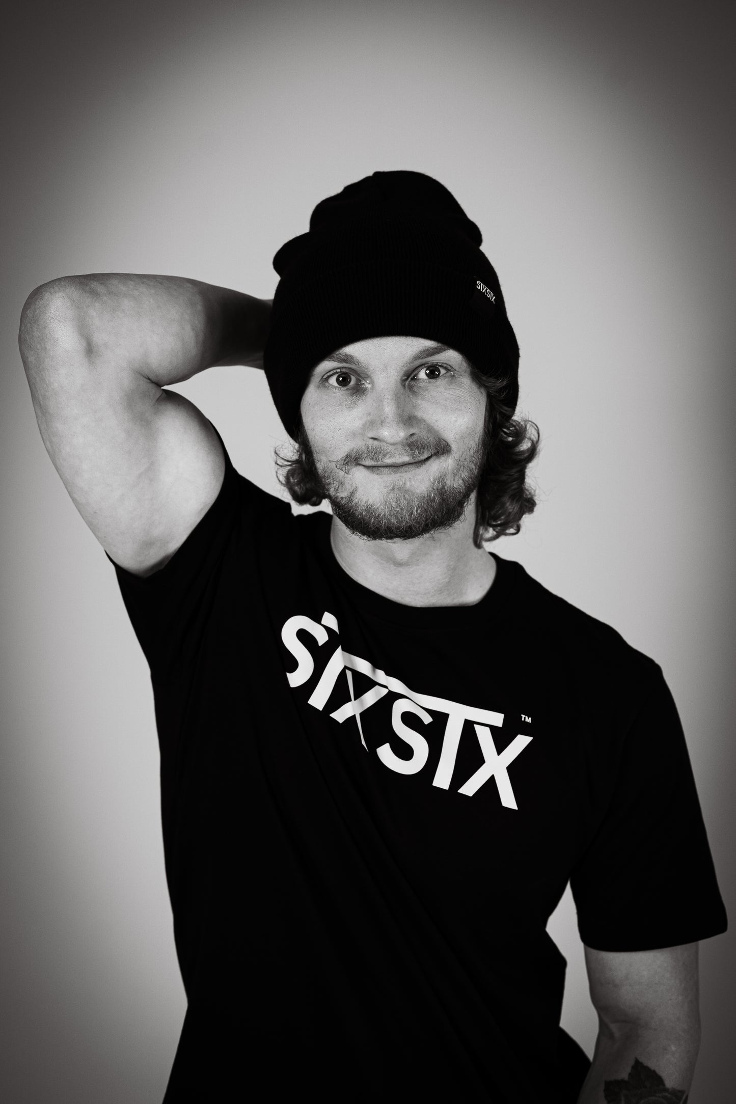 Man wearing a black tshirt with STXSTX logo in bold. also he is wearing a black STXSTX beanie