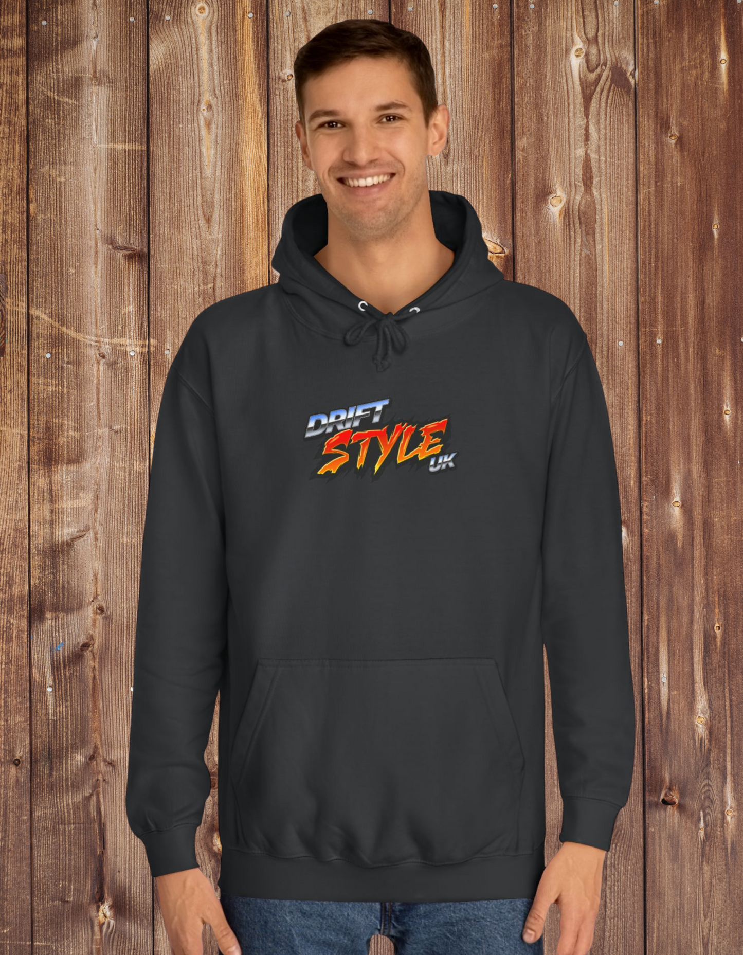A man wearing a black unisex hoodie with 'Drift Style UK' text on the front, featuring a hood, long sleeves, and a front pouch pocket.