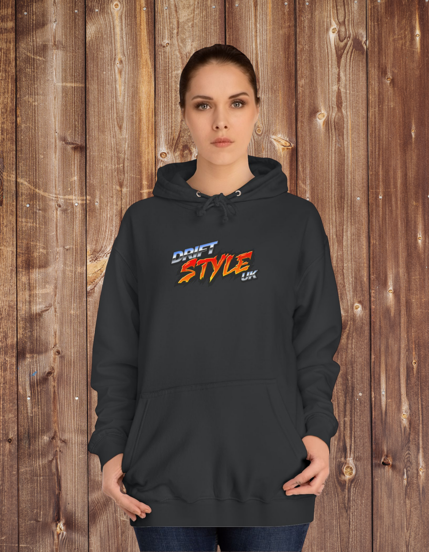 A women wearing a black unisex hoodie with 'Drift Style UK' text on the front, featuring a hood, long sleeves, and a front pouch pocket.