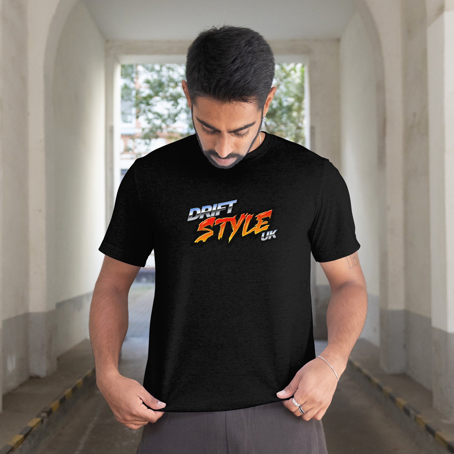 Man wearing a black t-shirt with 'DRIFT STYLE' text in a tunnel.