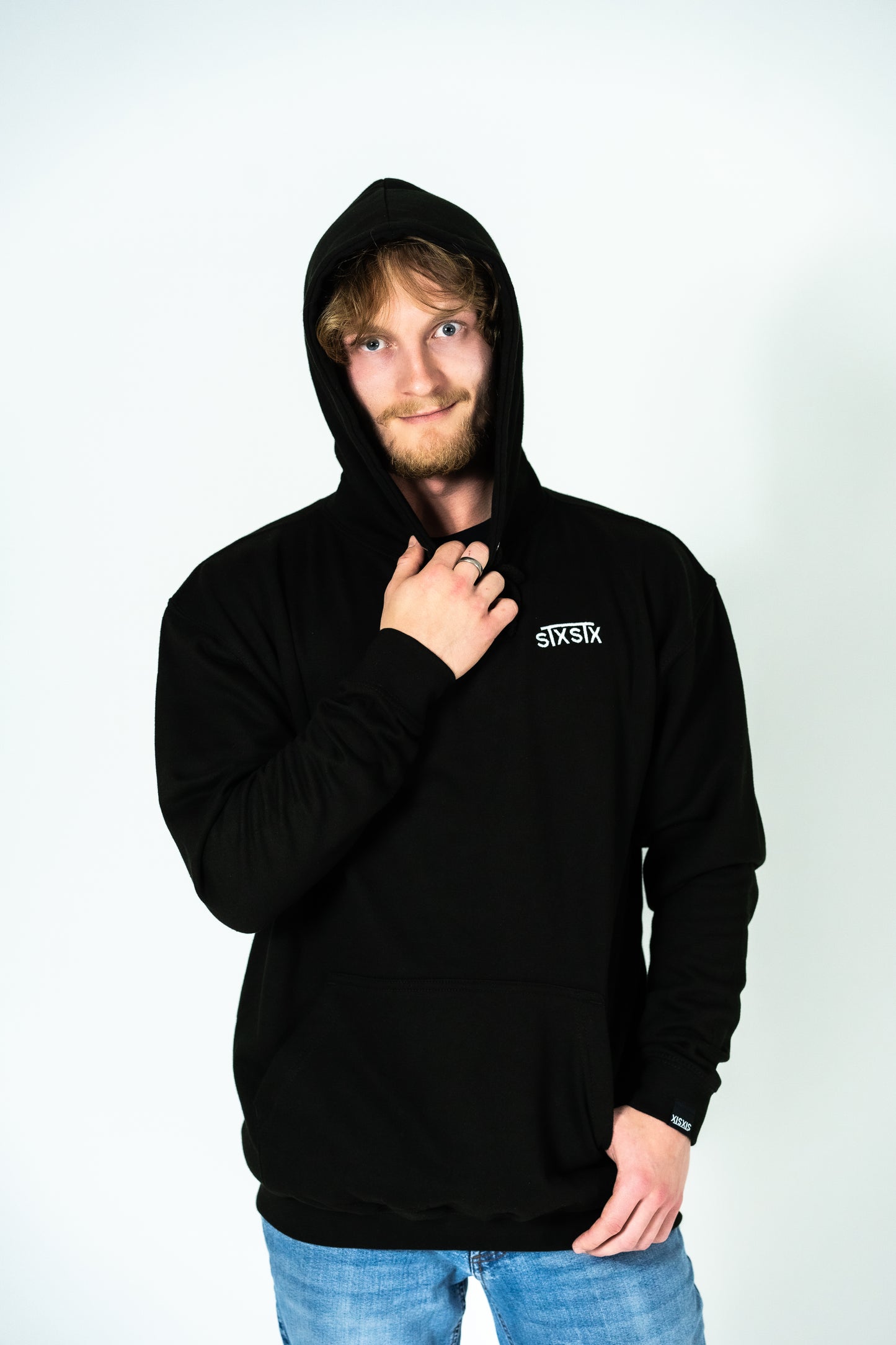 A person wearing a comfortable hoodie with a small embroidered STXSTX logo