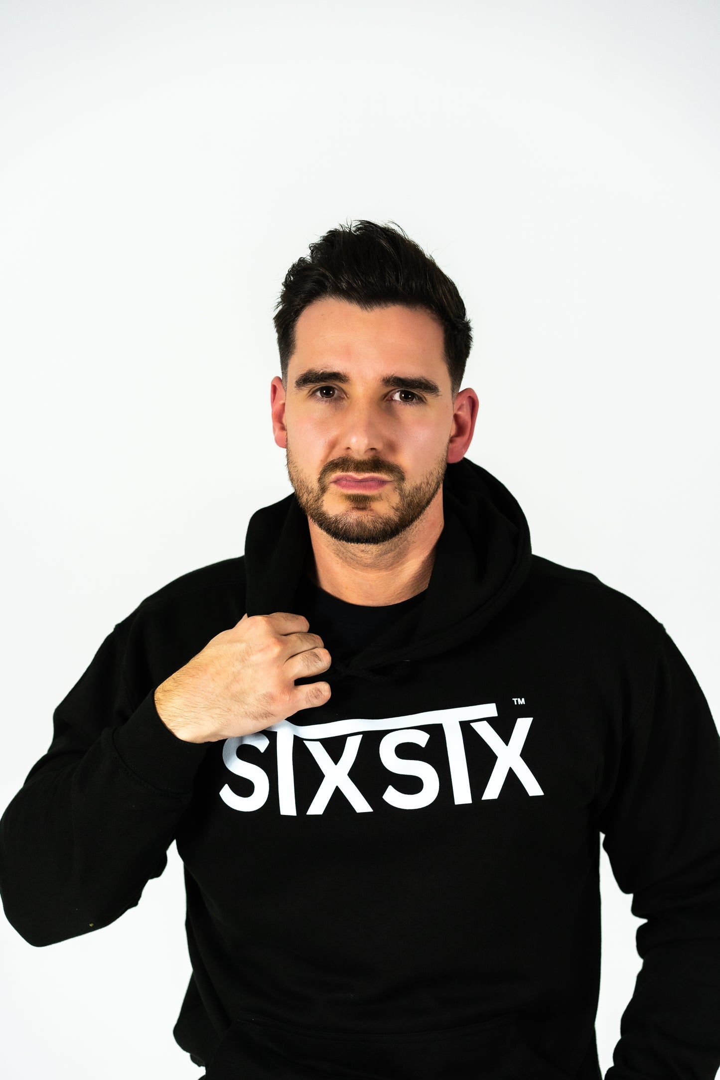 Man wearing a black hoodie with 'STXSTX' text on a white background