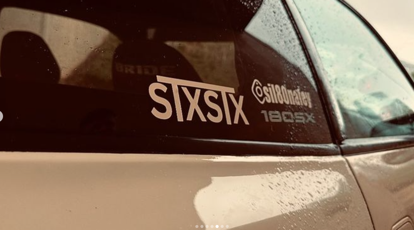 an stxstx sticker on the window of a nissan ps13