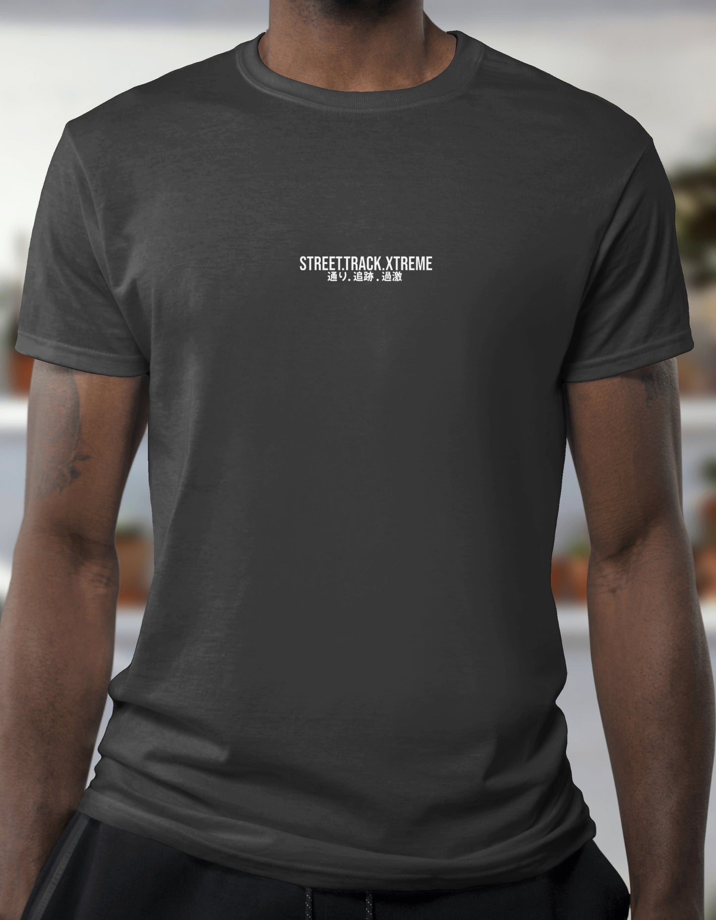 Person wearing a black t-shirt with 'STREETTRACK XTREME' text on a blurred background