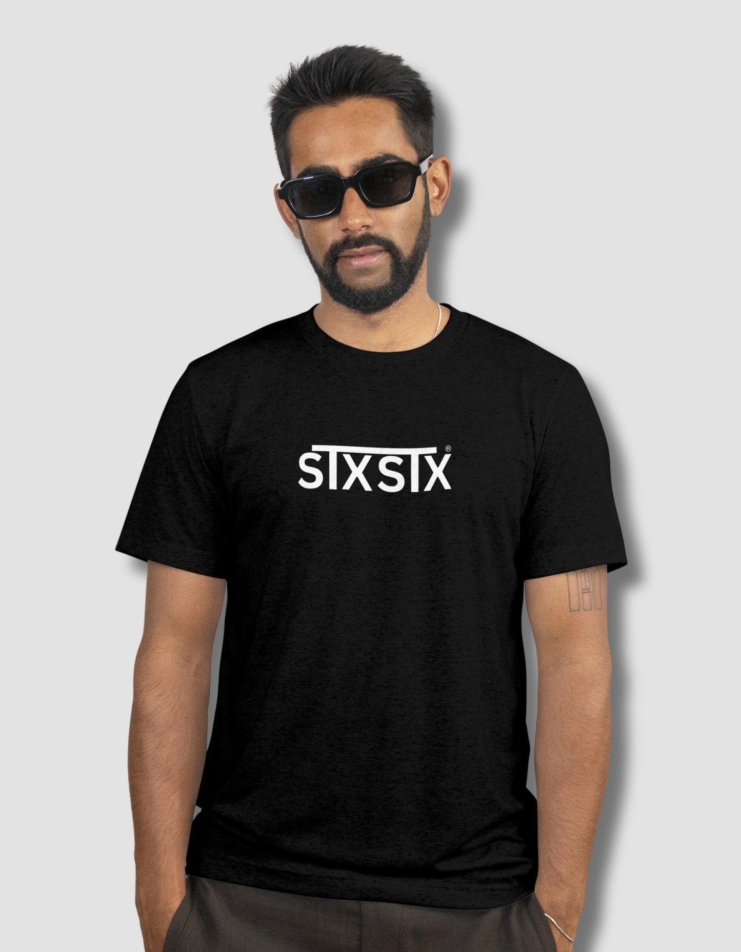 Man wearing a black t-shirt with 'STXSTX' logo on a plain background