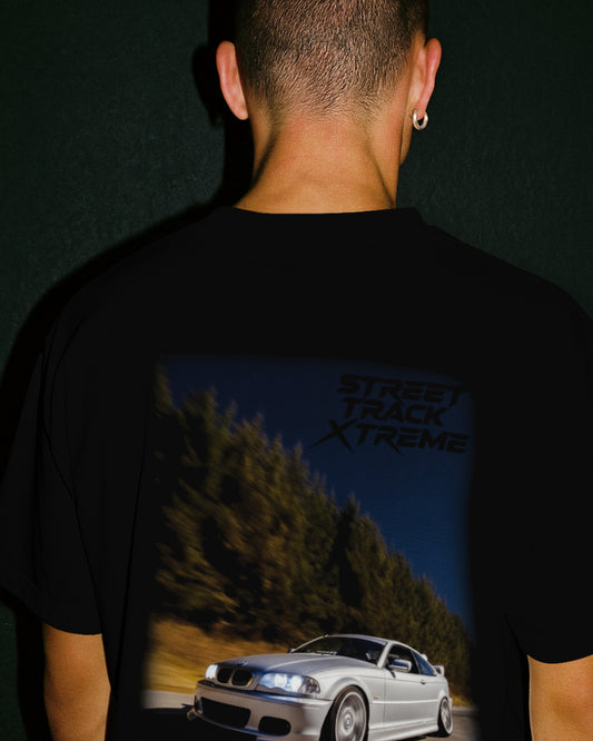 Black premium stxstx t-shirt with a bmw e46 drift car graphic and 'Street Track Xtreme' text on the back, worn by a person. black background