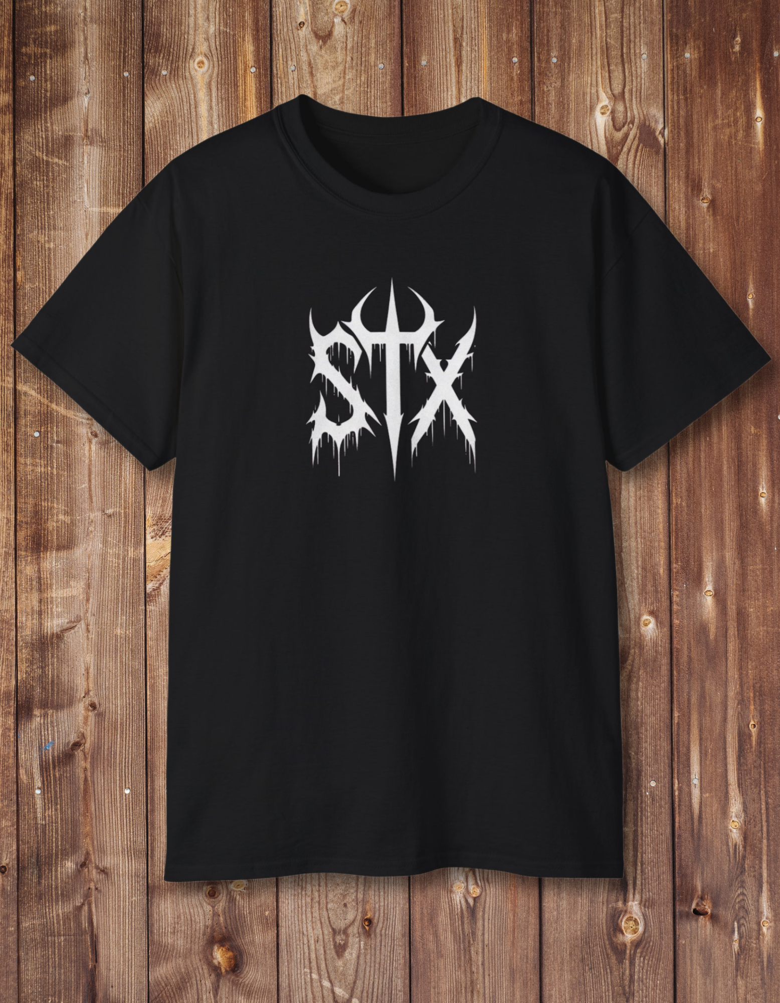 A black unisex t-shirt with a bold white graphic text 'STXSTX' on the front, displayed on a wooden background.