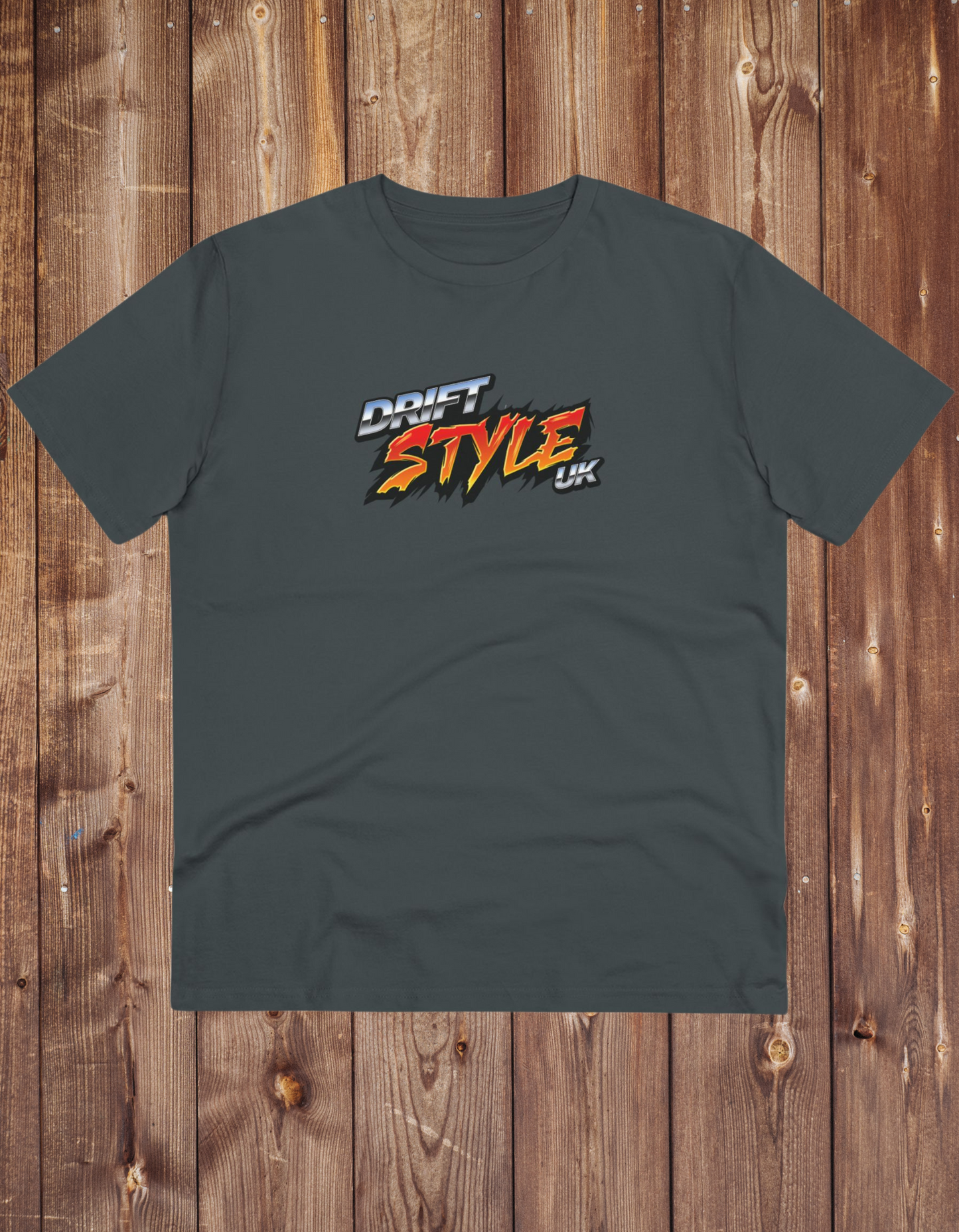 A grey unisex t-shirt with 'DRIFT STYLE UK' text on the front, displayed on a wooden background.