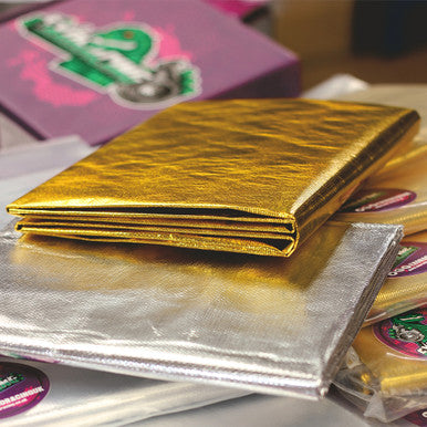 A gold heat reflective sheet with a self-adhesive backing, placed on top of a silver reflective sheet, with an exoracing logo and text in the background.