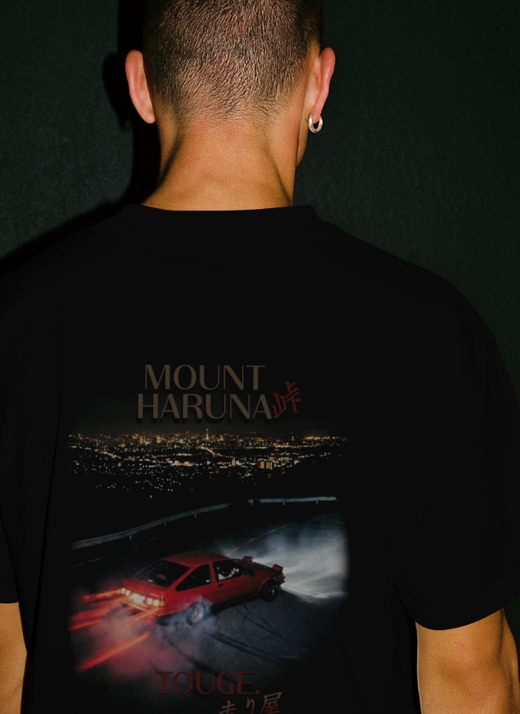rear view of male model wearing Premium Black STXSTX Tshirt With a design of an aae86 drift car on mount haruna 