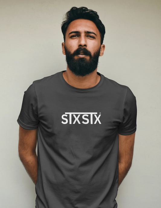Man wearing a dark gray t-shirt with 'STXSTX' logo against a plain background