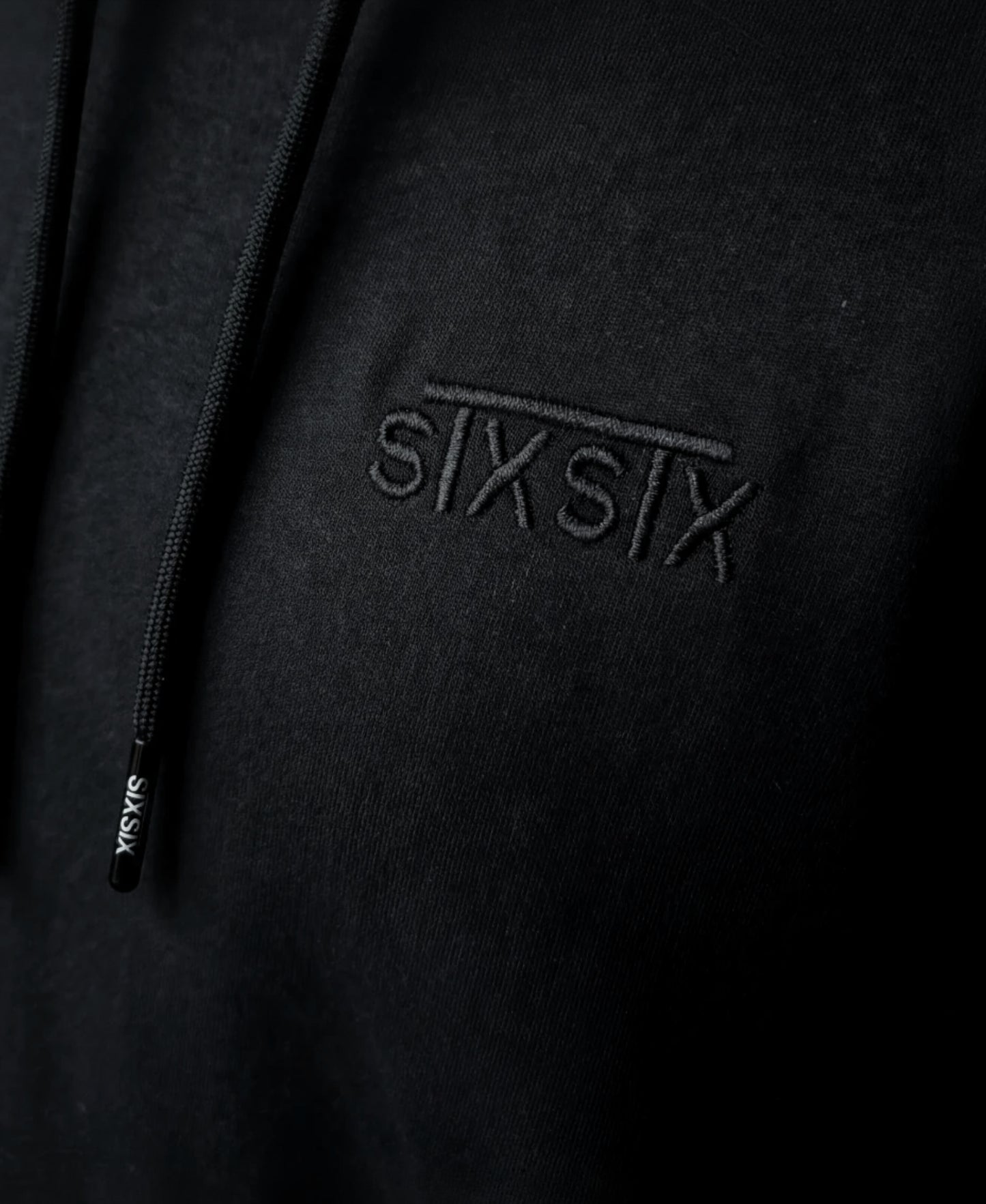 Black stxstx premium hoodie, close up shot of the high quailty emboidered logo