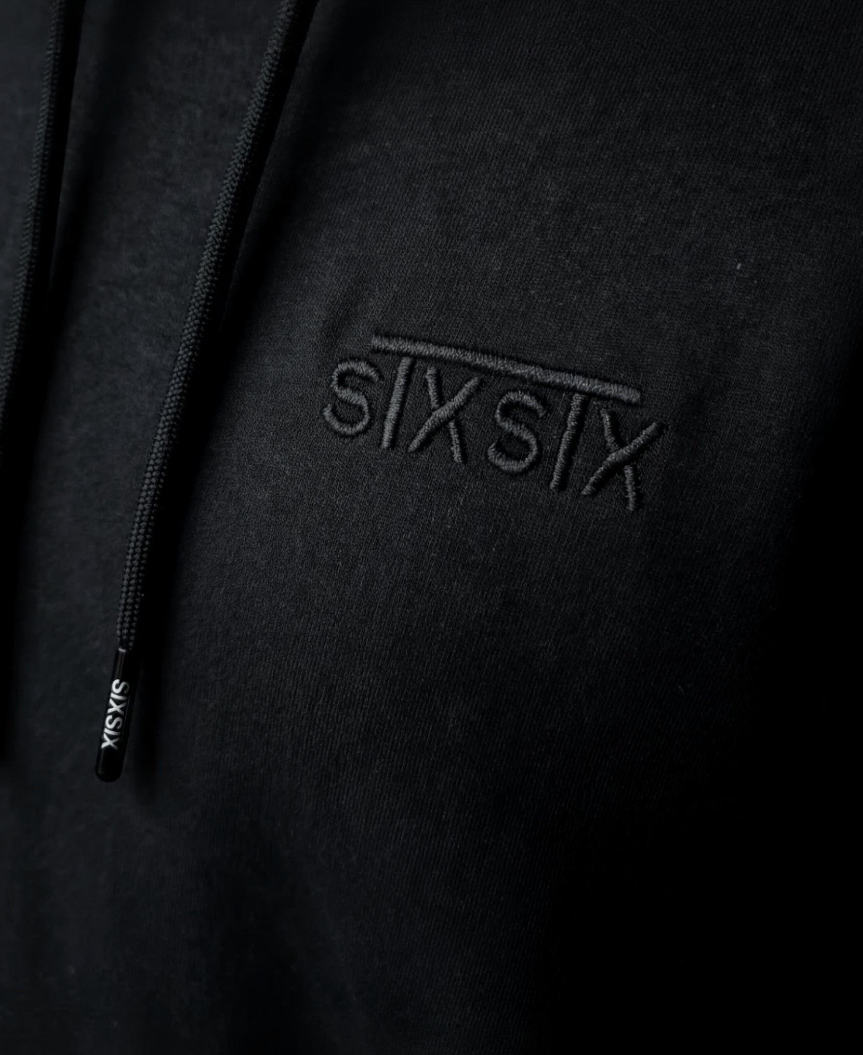 Black stxstx premium hoodie, close up shot of the high quailty emboidered logo