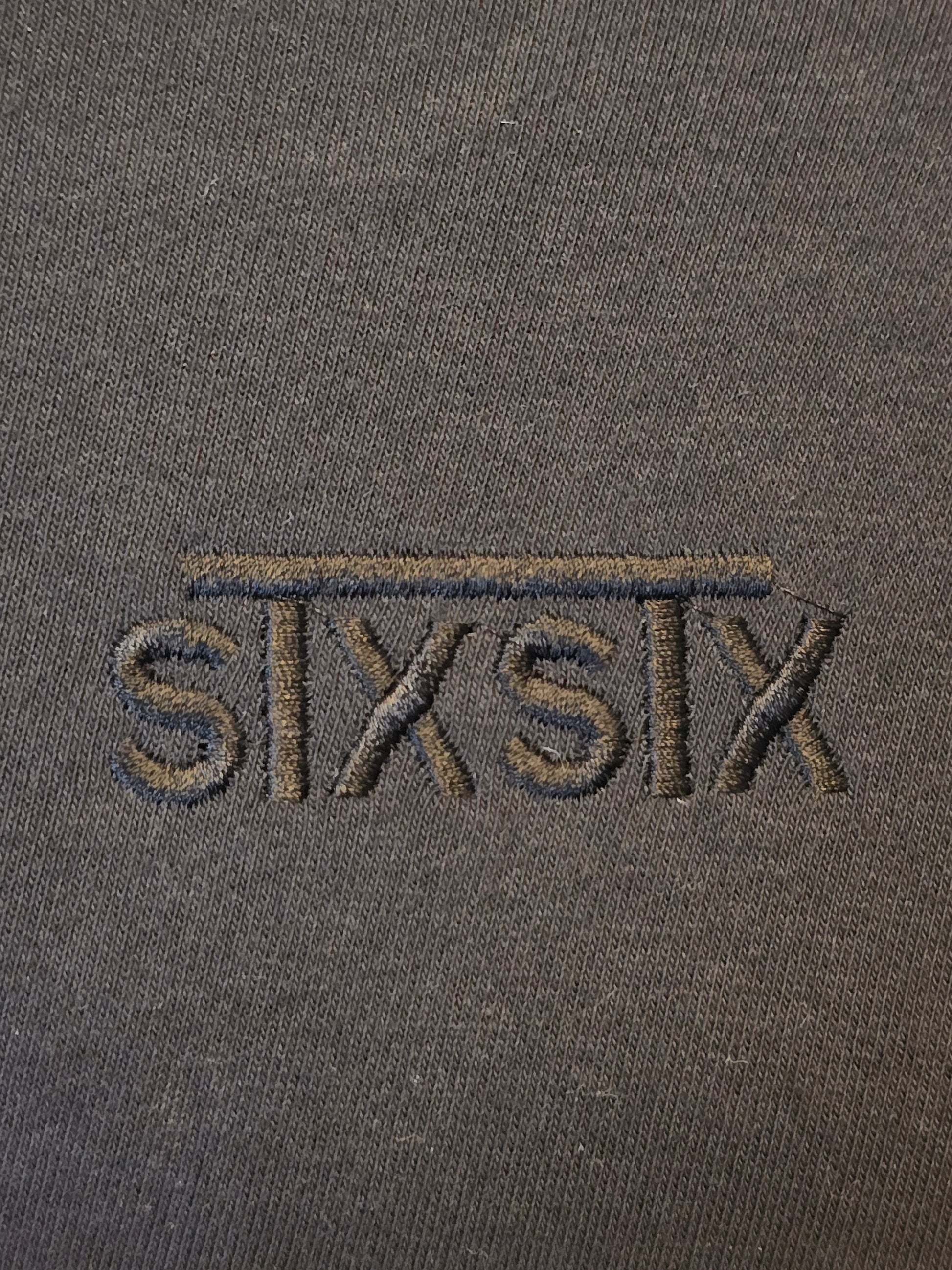 A close up of a premium black stxstx embroidered logo on a premium black hoodie
