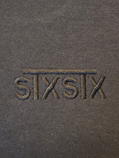 A close up of a premium black stxstx embroidered logo on a premium black hoodie